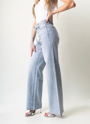 Pantalon wide leg azul con brillos visto de lado y cinturón ajustable.