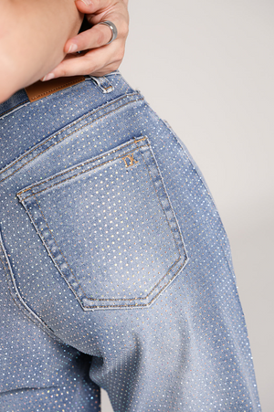 Detalle de los brillos y bolsa trasera del pantalon wide leg azul para mujer.