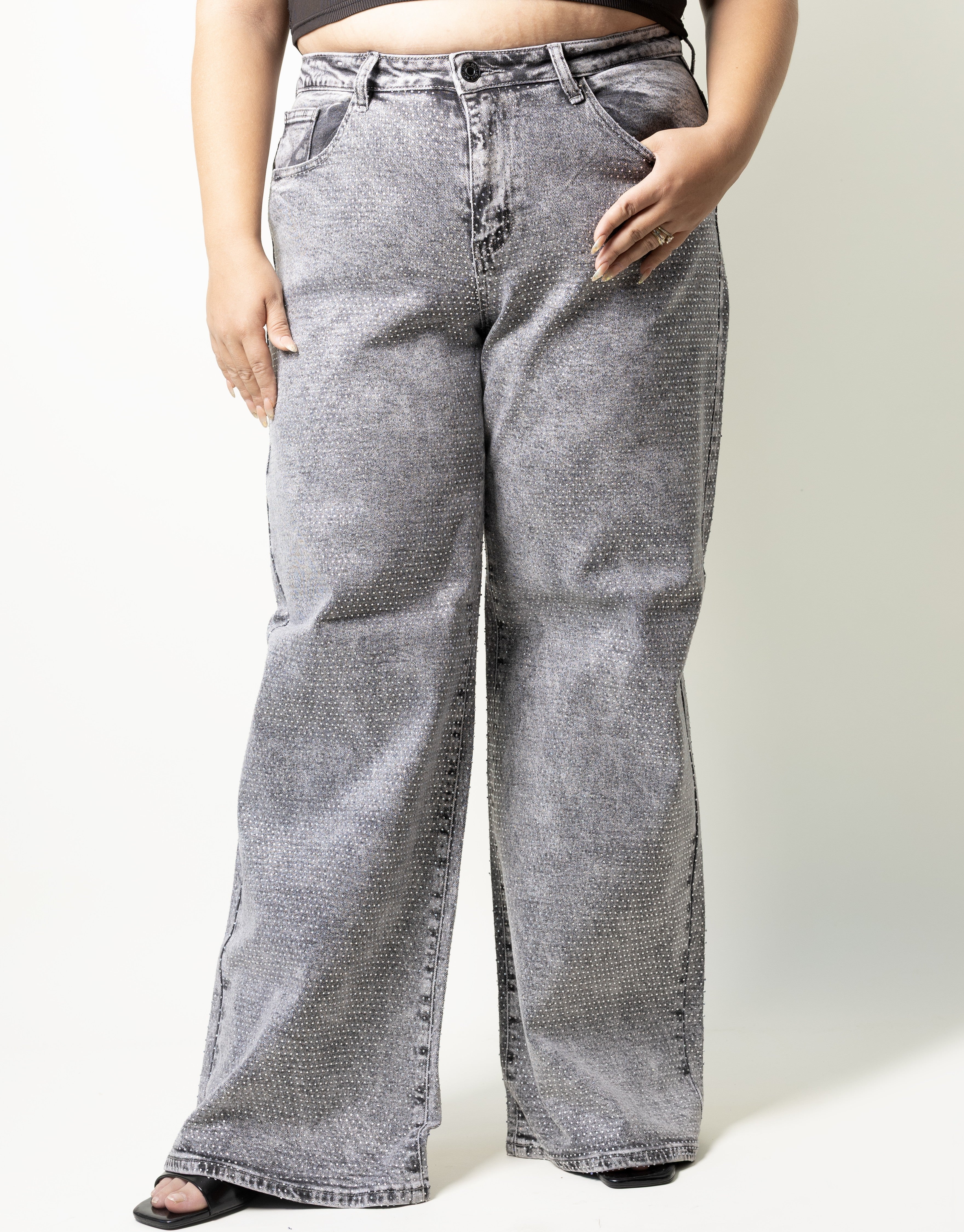 Pantalon wide leg curvy color gris con pedrería decorativa en toda la prenda, vista frontal.