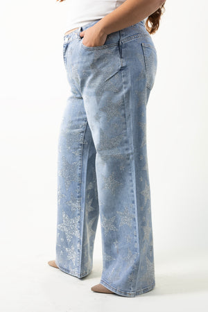 Detalle de pantalon wide leg curvy azul claro con estrellas de pedrería y bolsillo trasero.
