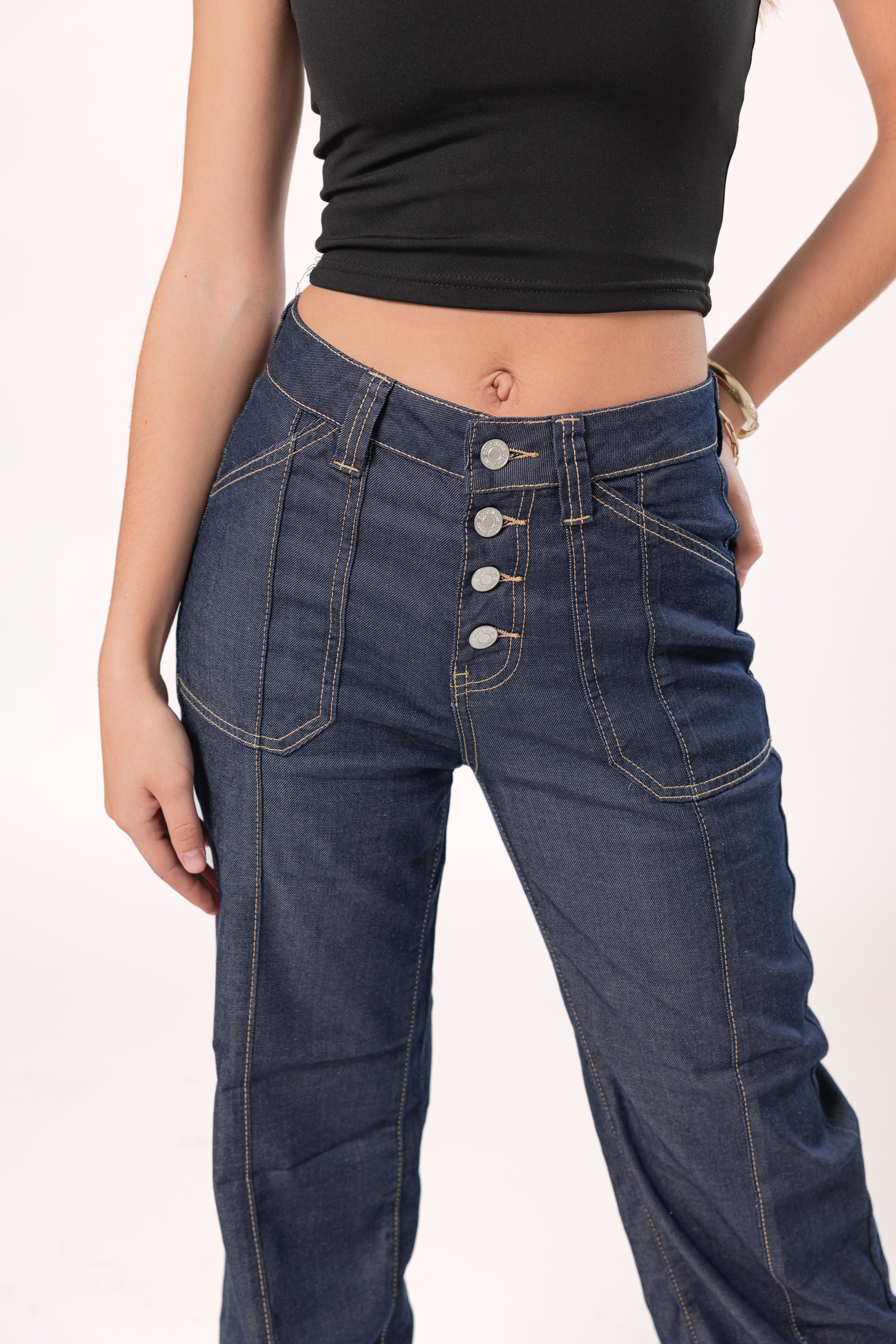 Detalle frontal de pantalon wide leg azul oscuro con botonadura metálica y costuras visibles