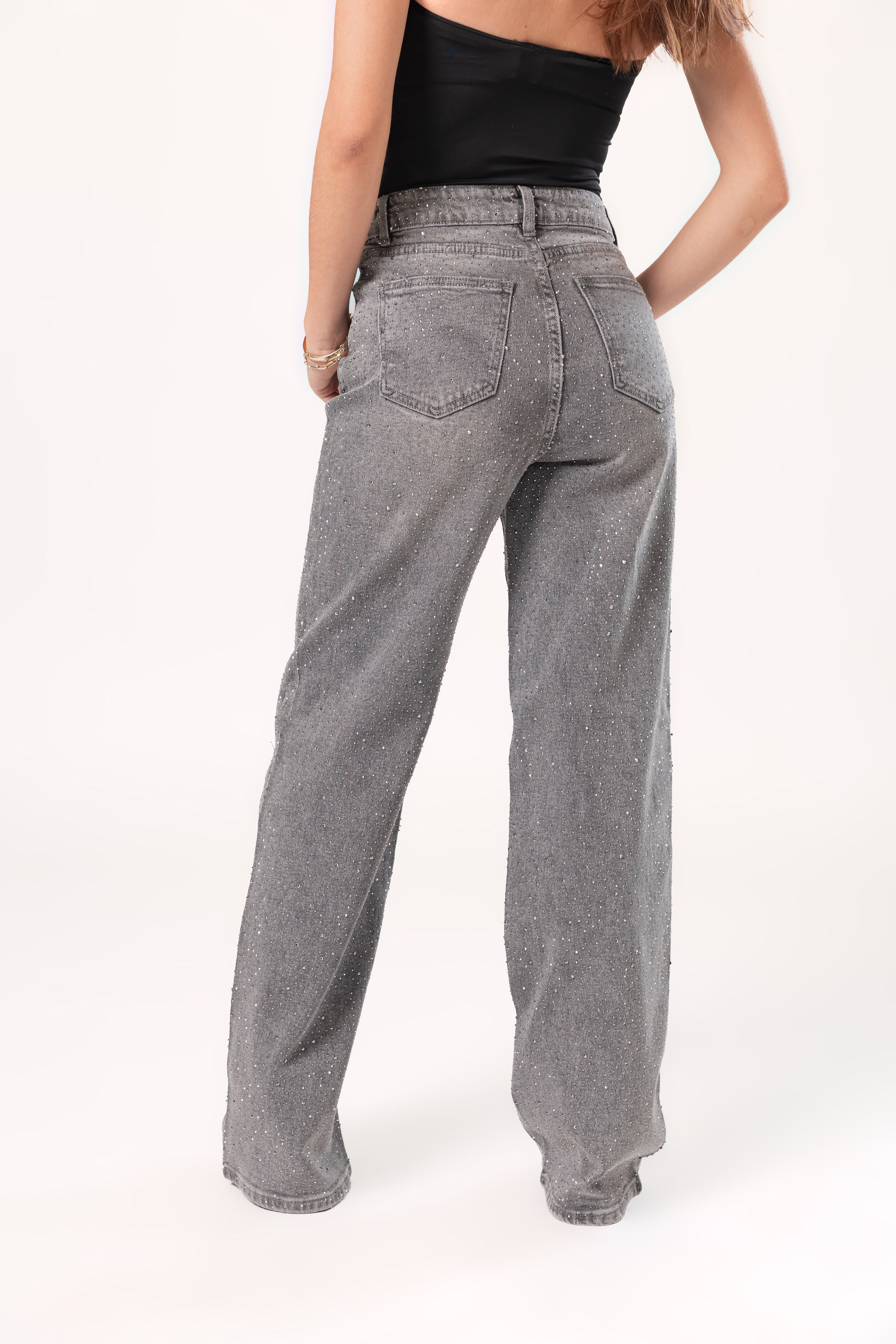 Vista trasera de pantalon wide leg gris con acabado brillante y silueta relajada