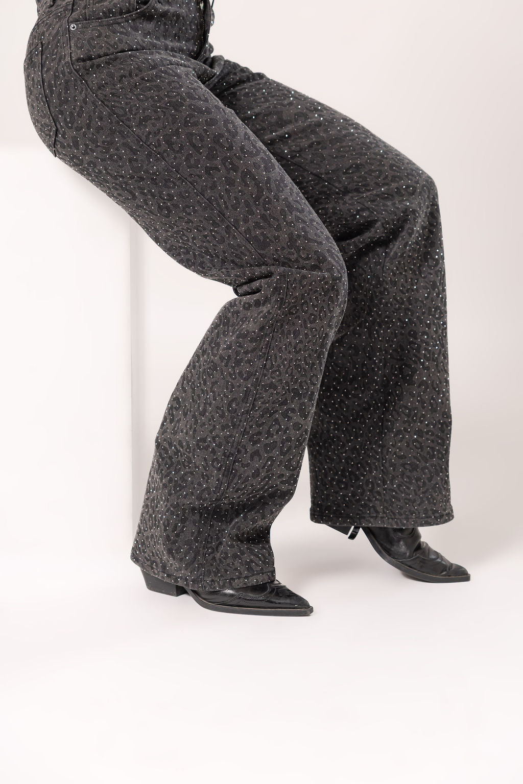 Detalle de pantalon wide leg black con textura animal print brillante y corte amplio
