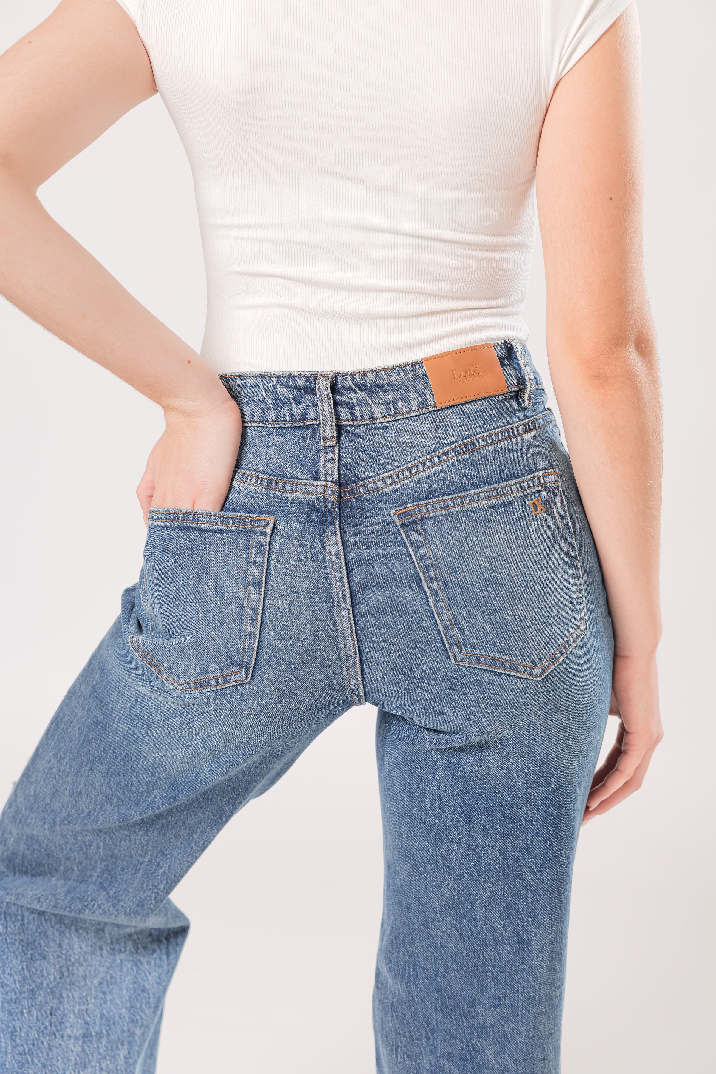 Detalle posterior de pantalon wide leg de mezclilla azul con bolsas traseras y acabado lavado