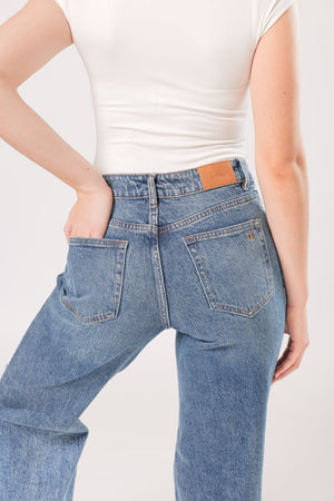 Detalle posterior de pantalon wide leg de mezclilla azul con bolsas traseras y acabado lavado