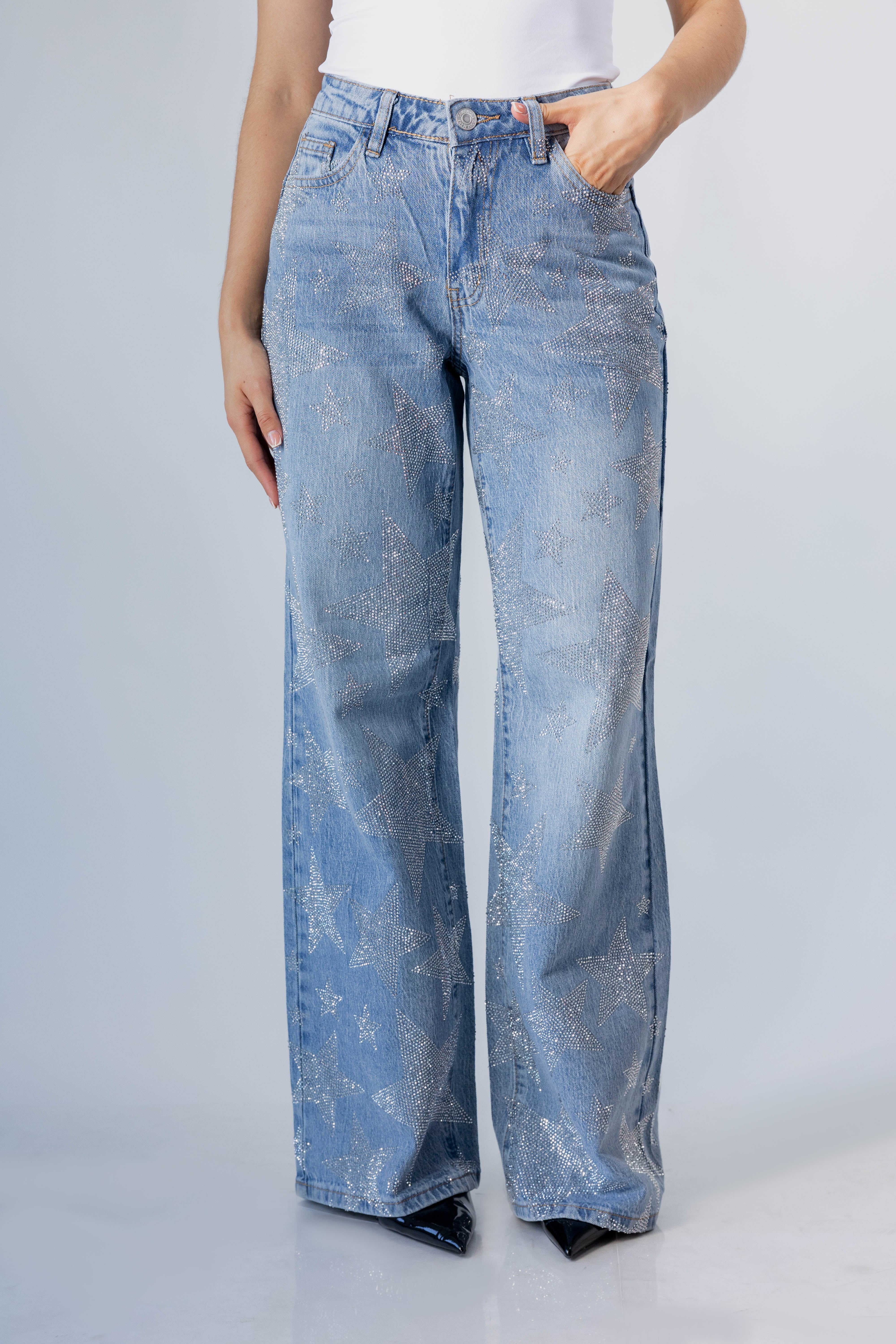 detalle frontal de pantalon wide leg azul claro con textura brillante y bolsillos