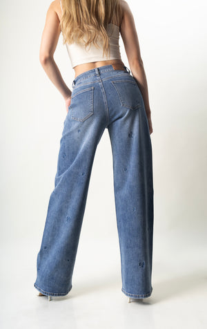 Pantalon wide leg azul con flores bordadas y brillos azules vista trasera.