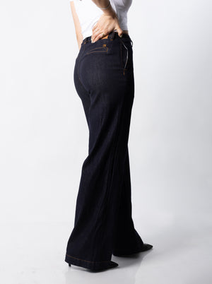 Vista lateral de pantalon wide leg índigo mostrando caída amplia y ajuste en cadera