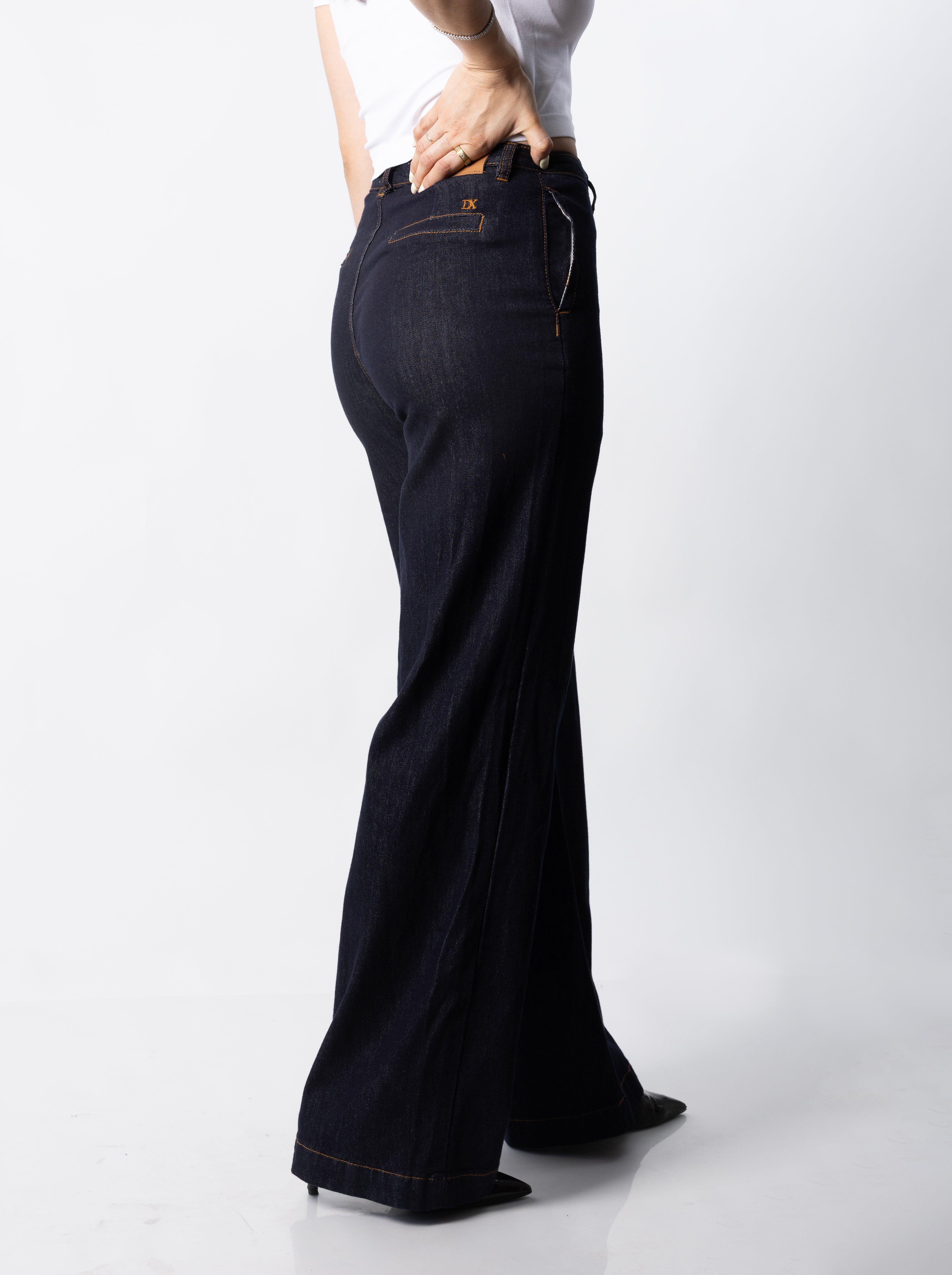 Vista lateral de pantalon wide leg índigo mostrando caída amplia y ajuste en cadera