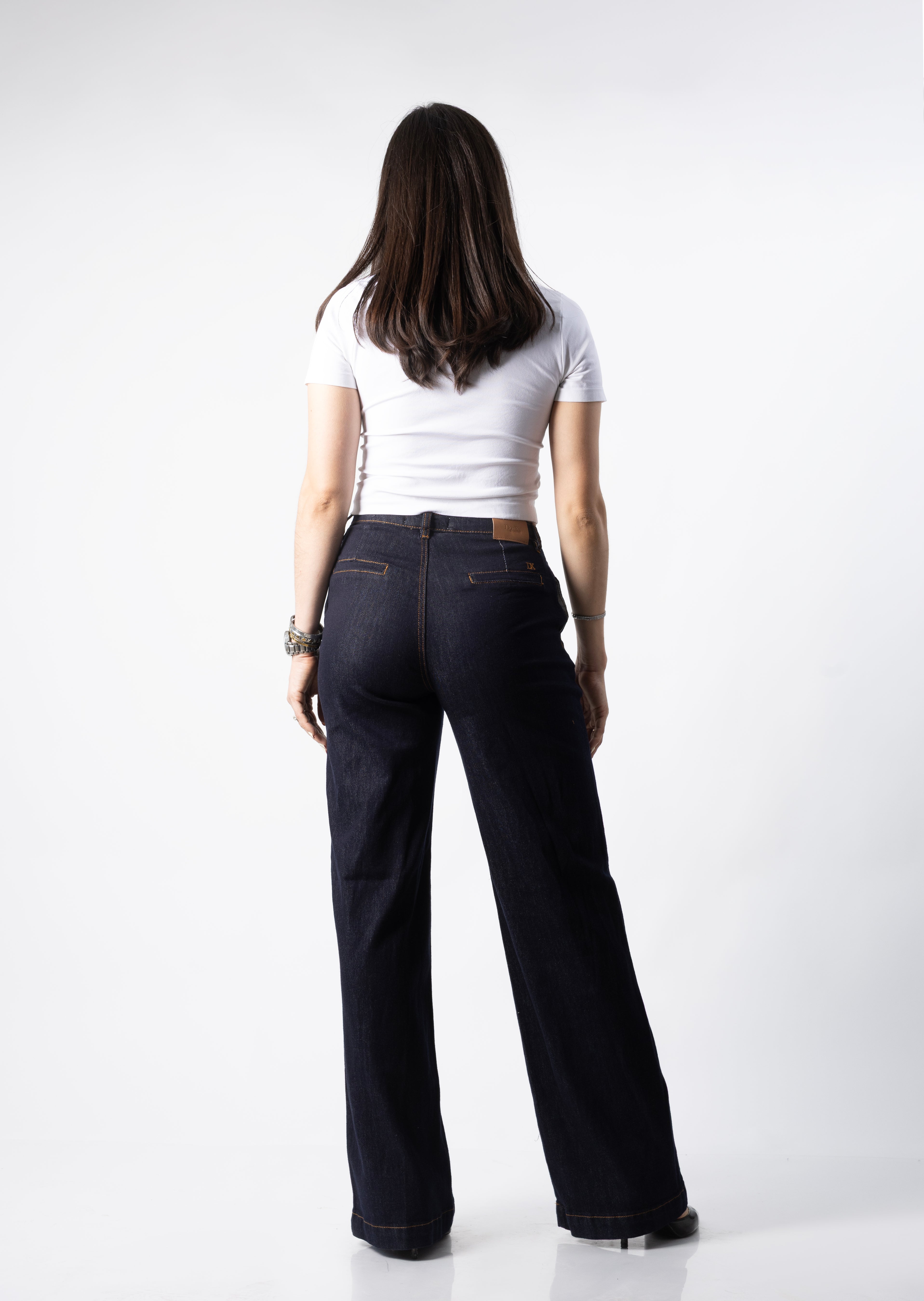 Vista trasera de pantalon wide leg azul oscuro con bolsillos posteriores y costuras en contraste