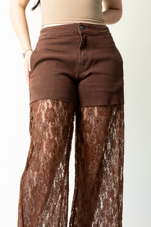 Detalle frontal de pantalon wide leg café con cintura de mezclilla y encaje floral.