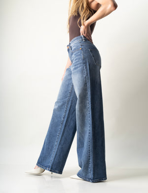 Pantalon wide leg azul denim con silueta amplia y caída fluida vista lateral.