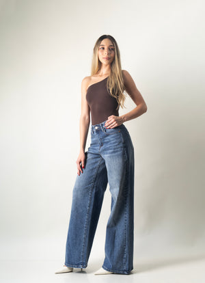Pantalon wide leg azul de mezclilla para mujer combinado con bodysuit asimétrico en look completo.