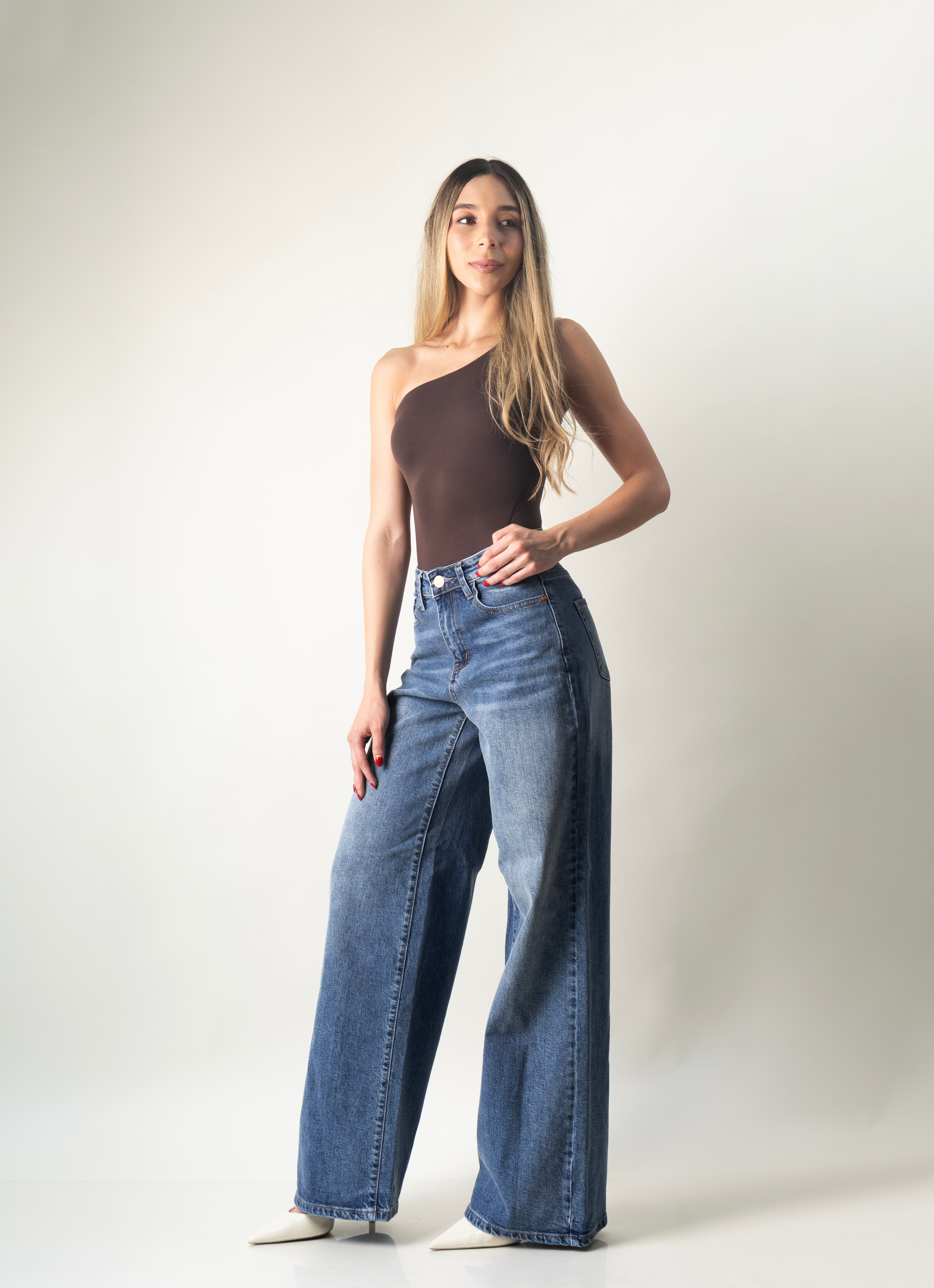 Pantalon wide leg azul de mezclilla para mujer combinado con bodysuit asimétrico en look completo.