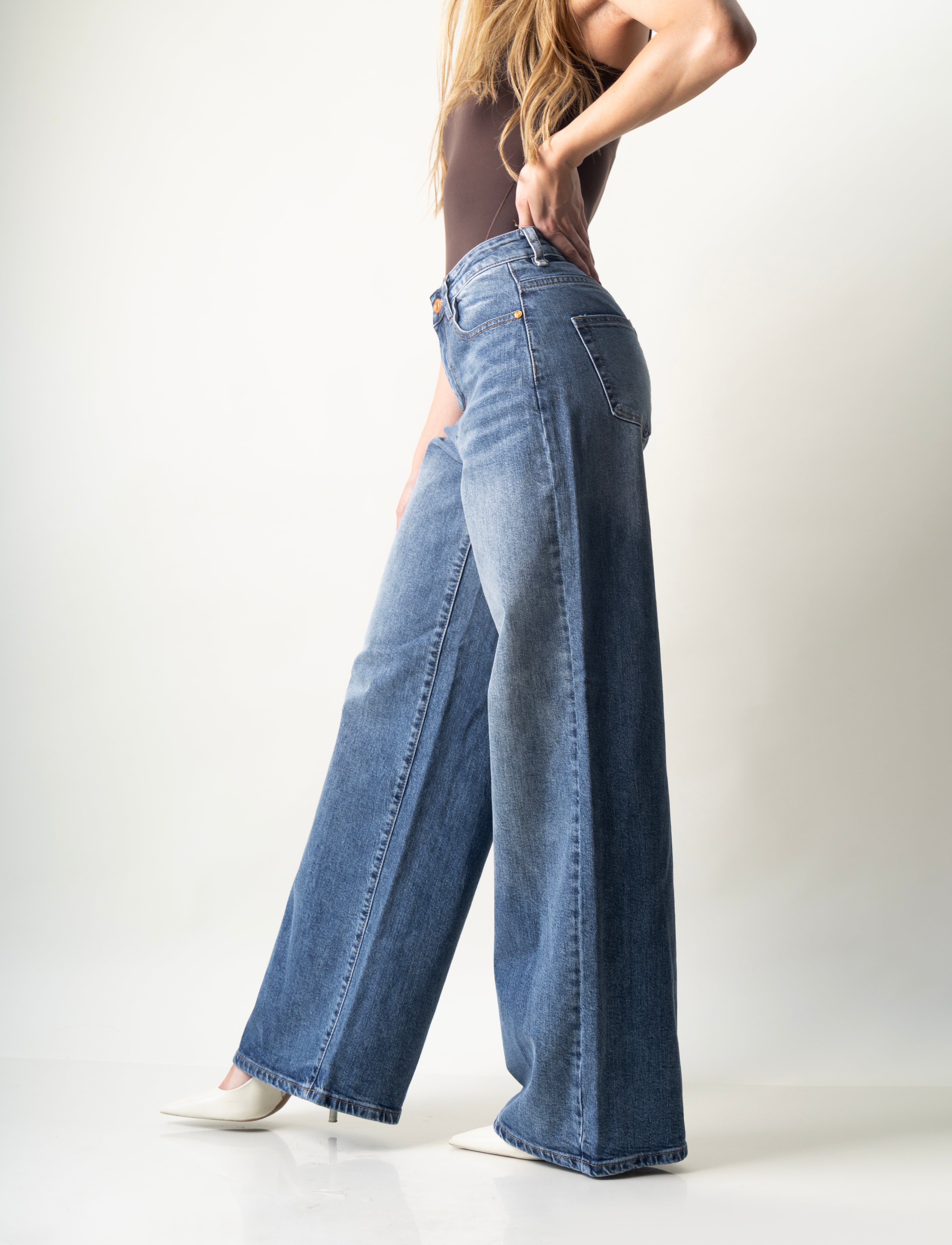 Vista lateral del pantalon wide leg de mezclilla azul con corte súper wide leg.