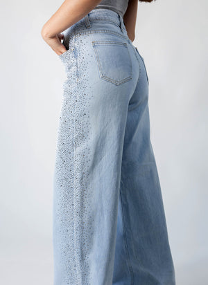 detalle lateral de pantalon recto azul claro con brillos en pierna