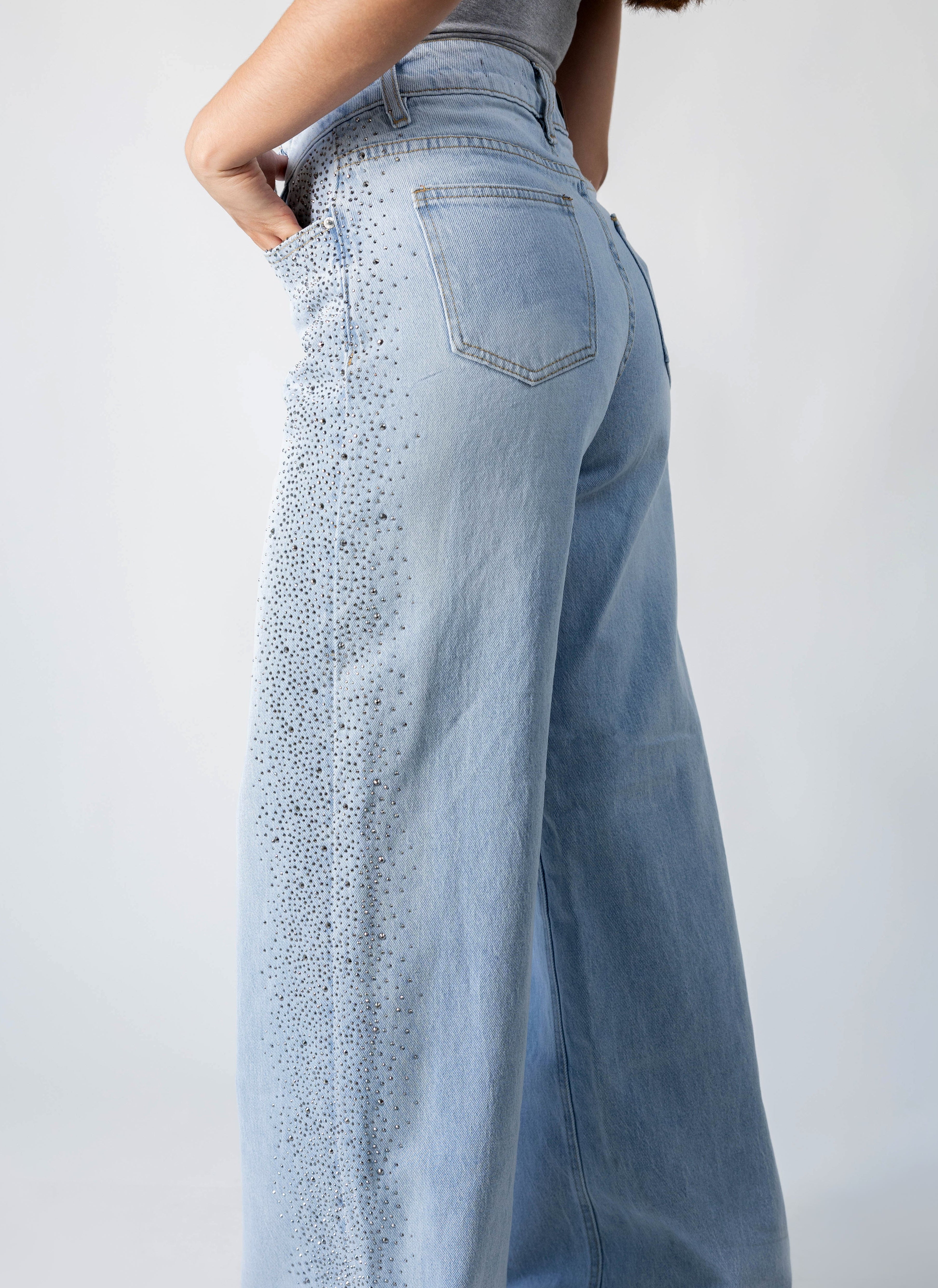 detalle lateral de pantalon recto azul claro con brillos en pierna
