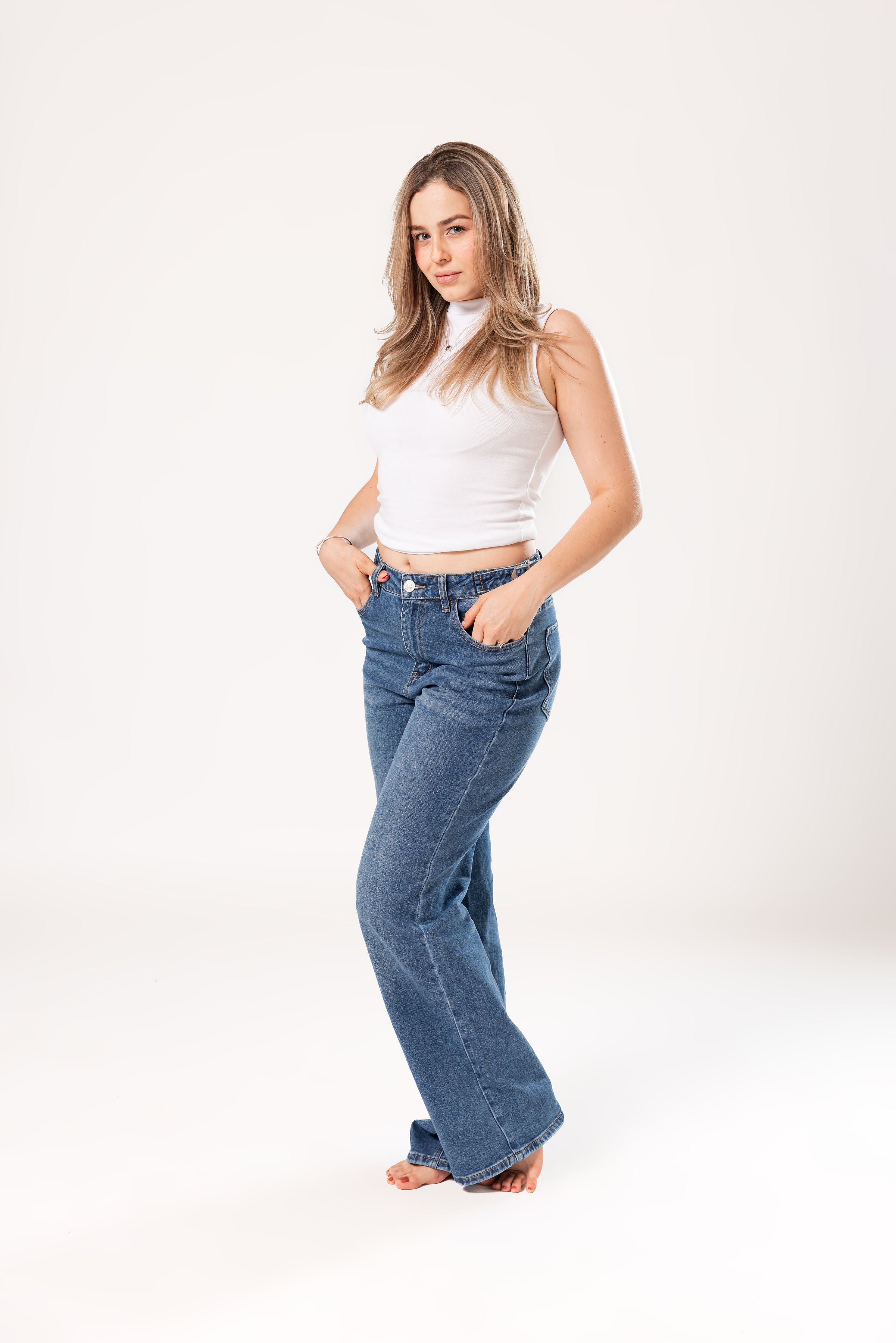 pantalon wide leg azul medio de mujer vista frontal con manos en bolsillos y corte amplio