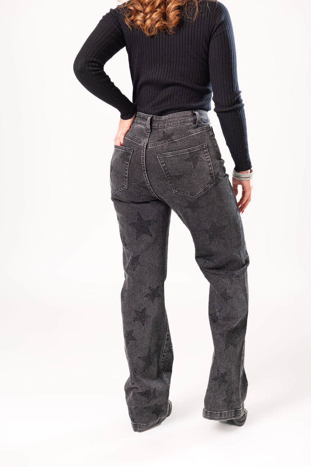Vista trasera de pantalon wide leg negro con aplicaciones de estrellas brillantes