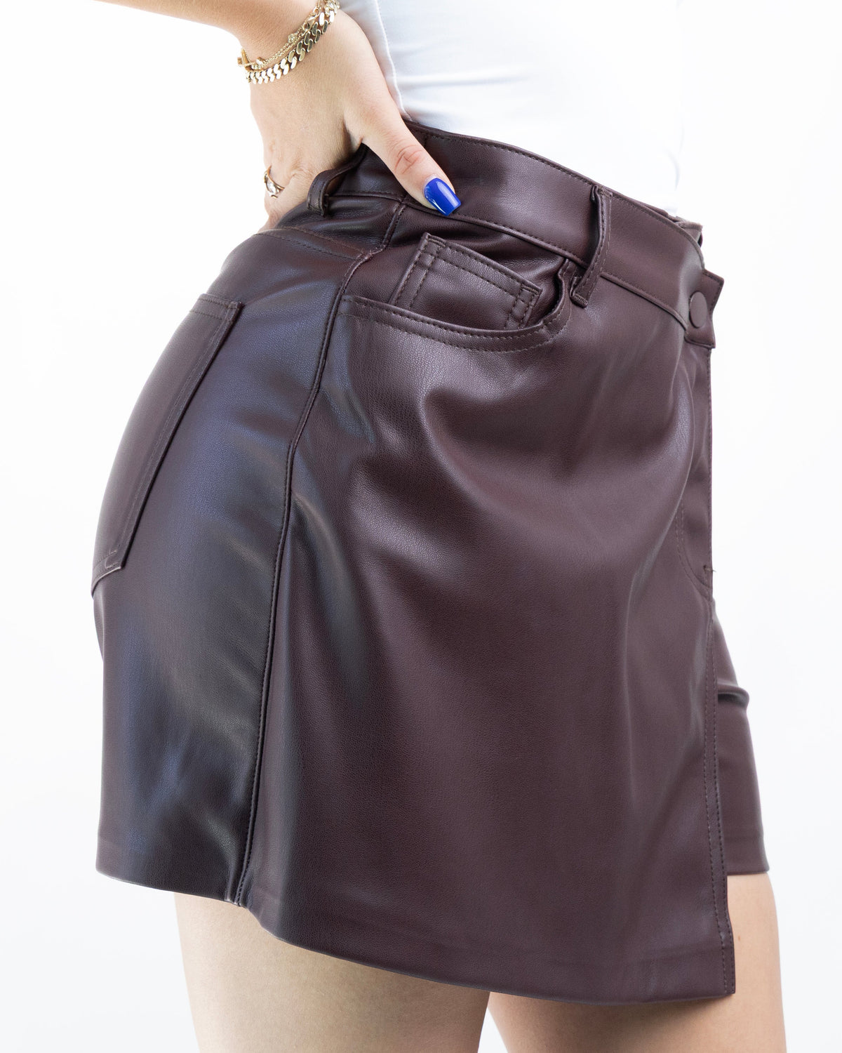 Detalle lateral de short falda burgundy de vinipiel con diseño cruzado