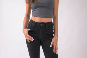 Detalle frontal de skinny jeans negros para mujer con tiro alto y acabado limpio