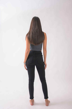 Vista trasera de skinny jeans negros para mujer con bolsillos funcionales y fit skinny